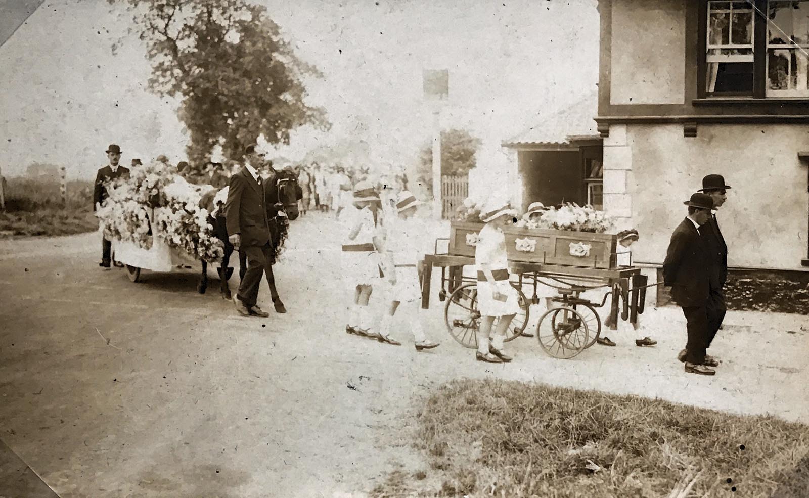 A funeral of a young girl directed by Harry March (the tallest of the two men at the front) in 1926. Taken on the corner of Holt Road & Church Street, Horsford.